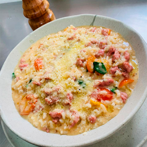 Risoto cremoso com linguiça, tomatinhos e queijo ralado