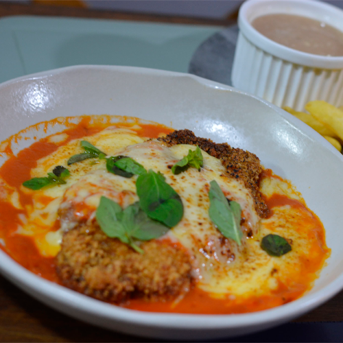 Parmegiana gratinada com molho de tomate e manjericão fresco